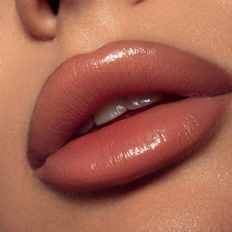 Close up of glossy lips showing lip blush tattoo